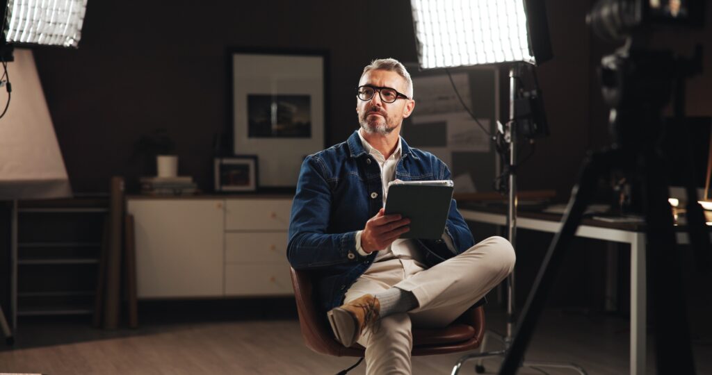 Live stream host, talk show and man with tablet in home studio for documentary interview or online